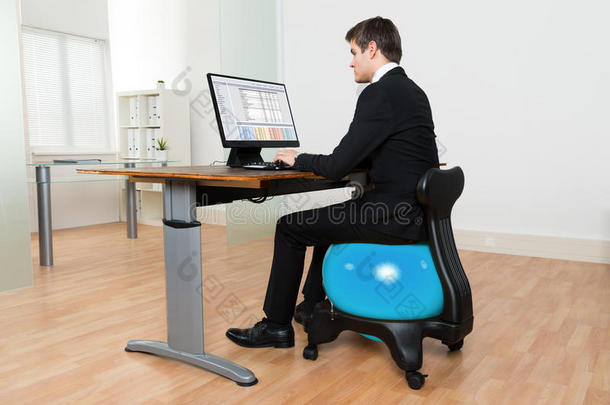 商人在<strong>电脑前坐在</strong>普拉提球上
