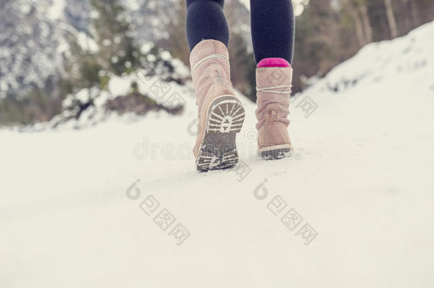 活跃的女人穿过冬天的雪离开相机