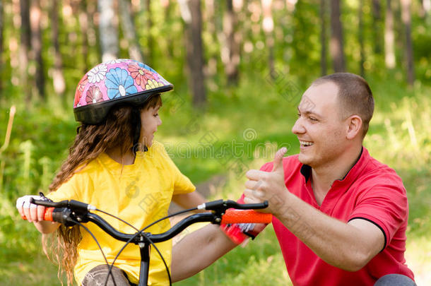 父亲赞扬他的女儿，她学会了骑自行车