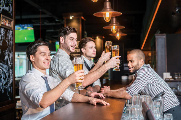 真正的男人在酒吧里喝啤酒的活动。另外三个人喝酒
