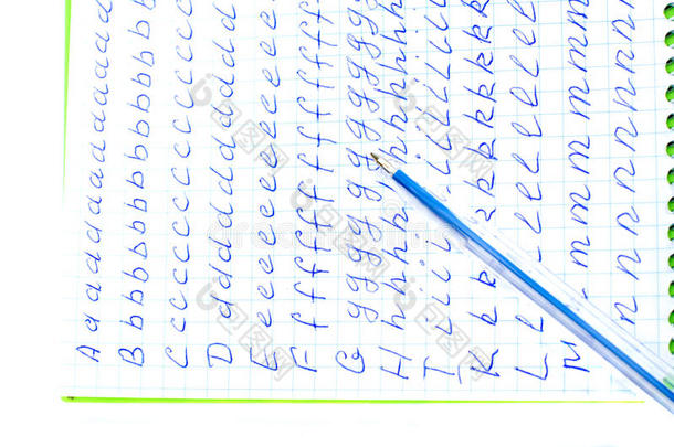 把笔记本上的字母表放到一个单元里。上面是蓝色的钢笔。隔离。