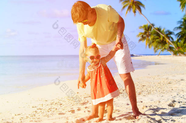 父亲和小女儿在海滩上散步