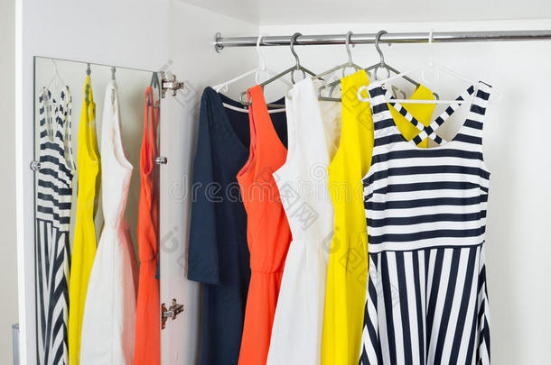 一系列明亮的现代时尚女装挂在衣架上