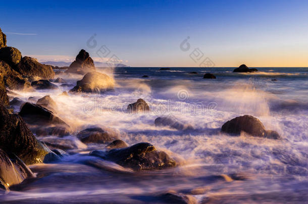 日落时在梦幻般的加州海滩上撞击海浪
