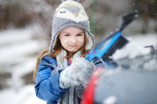 可爱的小女孩帮助刷雪