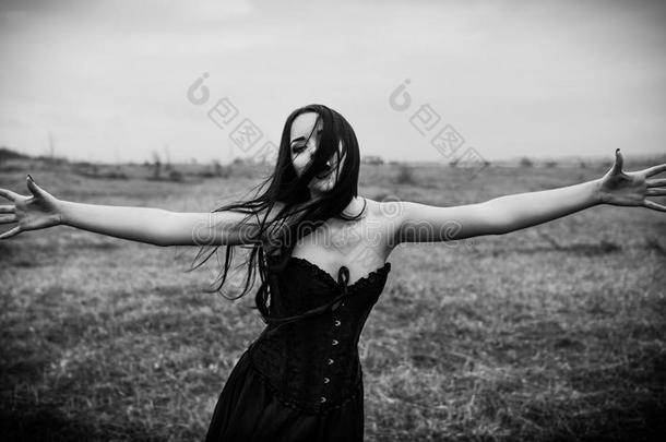 在秋天的田野里哭着悲伤的哥特式女孩。 黑白相间