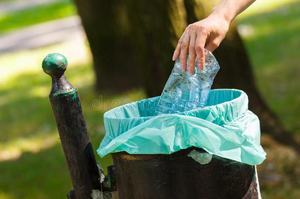 女人的手把塑料瓶扔进回收站，乱扔环保垃圾