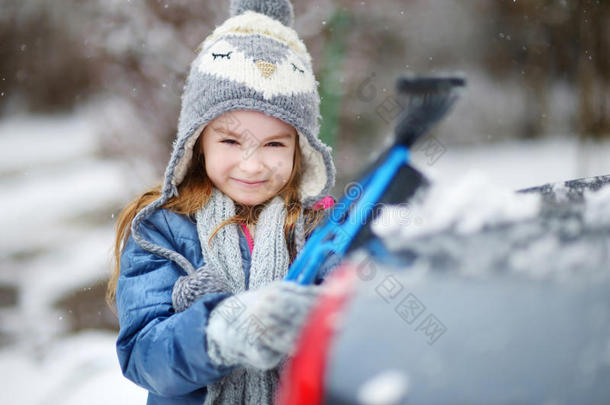 可爱的小女孩帮助刷雪