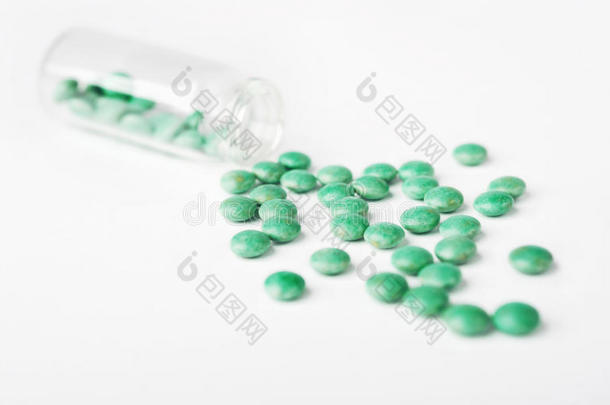 绿色从瓶子里溢出的药丸。