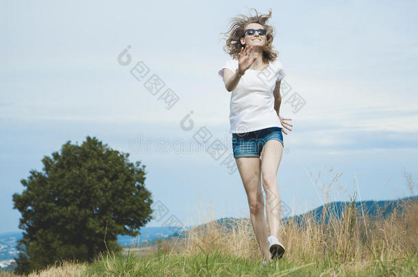 快乐的女人在草地上跳跃。