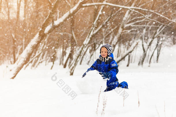 可爱的小<strong>男孩</strong>在冬天<strong>堆雪人</strong>