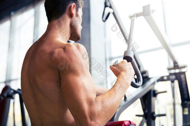 健美运动员在健身房健身机上做运动