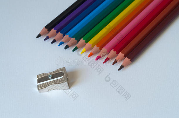 彩色铅笔与卷笔刀在一张<strong>白纸板</strong>上