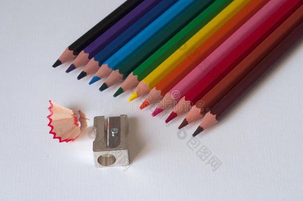 彩色铅笔与卷笔刀在一张白纸板上