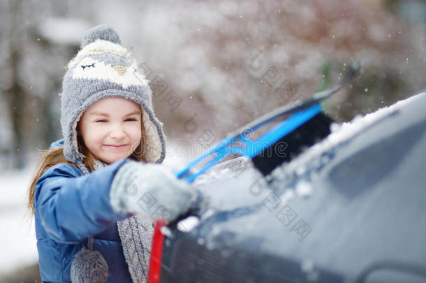 可爱的小女孩帮助刷雪