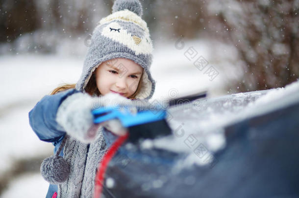 可爱的小女孩帮助刷雪