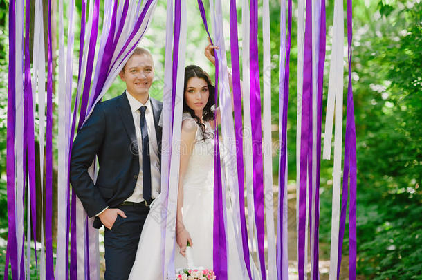 美丽的年轻新娘和新郎在婚礼的背景下，多色丝带，婚姻，关系，c