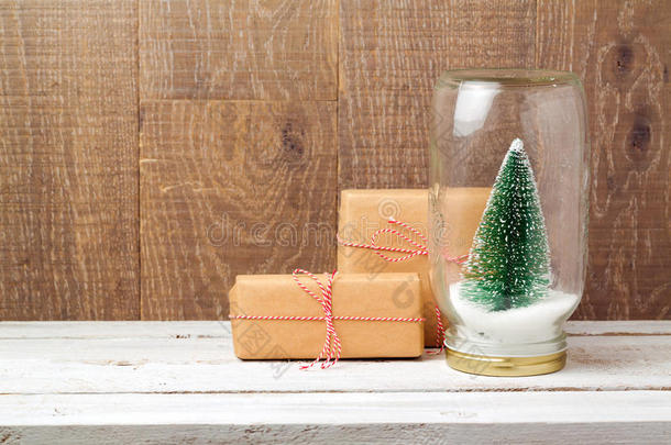 圣诞礼品盒和木制背景玻璃罐中的圣诞树