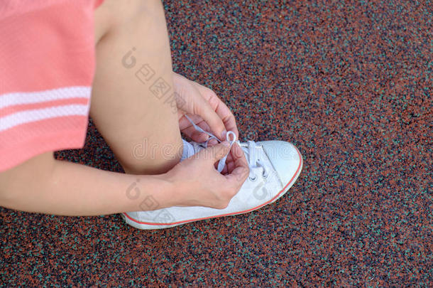 女跑步者系着她的运动鞋