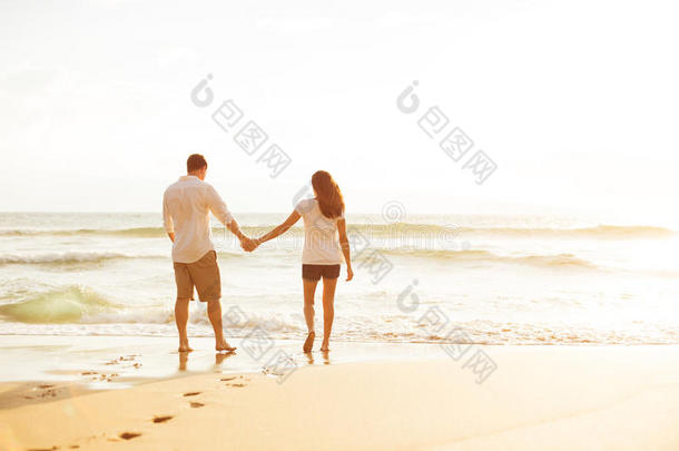 日落时分，一对情侣在海滩上散步