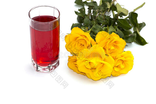 一杯红色的果汁和一束明亮的黄色玫瑰在左边