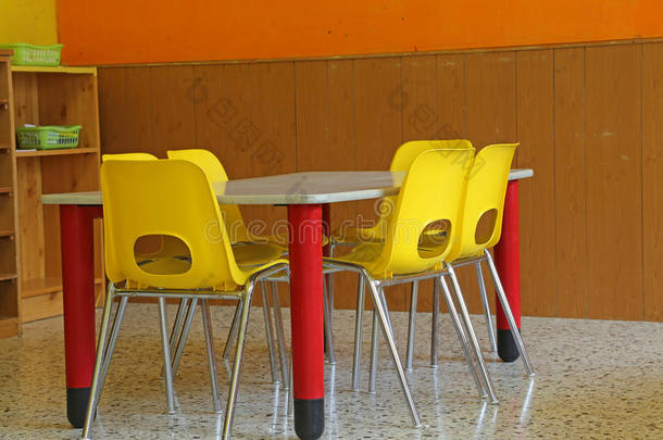 教室里有桌子和黄色椅子，没有孩子