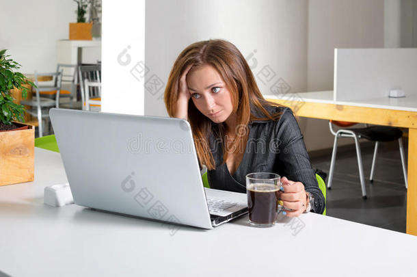 <strong>坐</strong>在<strong>电脑前</strong>的沮丧的女商<strong>人</strong>。 又累又困的上班族看着笔记本<strong>电脑</strong>屏幕，需要帮助。