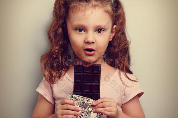 有趣的表情，小女孩吃黑巧克力，看<strong>上去</strong>很开心。
