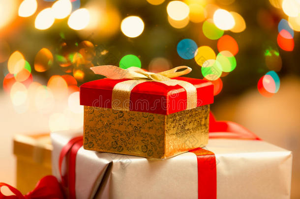 红色圣诞<strong>礼盒</strong>的特写，<strong>金色</strong>丝带和蝴蝶结