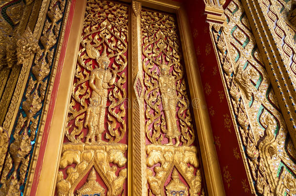 关闭红色佛教寺庙大门与黄金雕塑创作