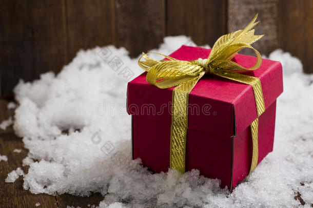 圣诞礼物盒，雪上有金色丝带蝴蝶结