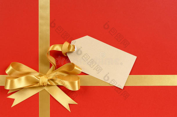 圣诞礼物红色背景，金色丝带蝴蝶结，礼品标签，复印空间