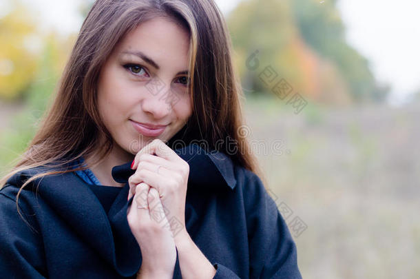穿着外套的迷人女孩在秋天温柔地微笑