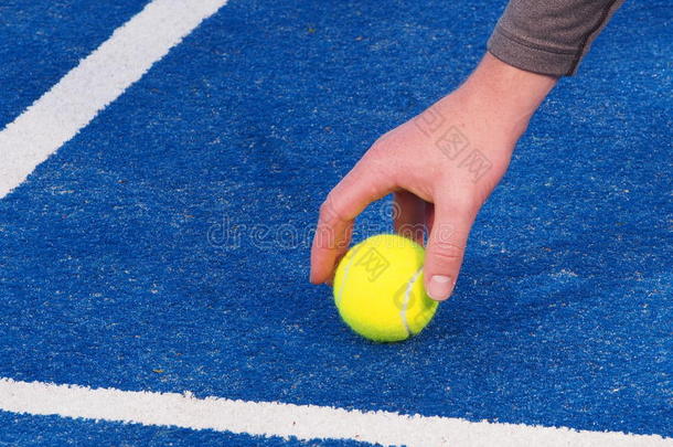 一个球童拿起网球的手