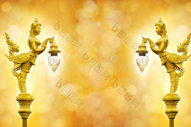 天使的金色雕像拿着博克背景上的灯