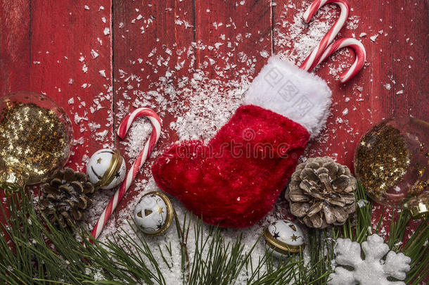 圣诞背景与糖果松枝和松果，圣诞袜子雪花和雪在红色木制乡村背景