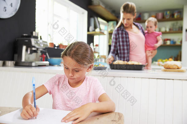 女孩画画，因为母亲在厨房准备饭菜
