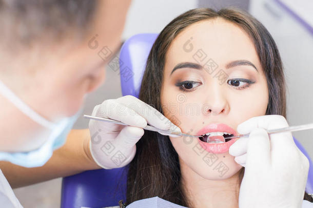 牙医医生在牙科办公室治疗牙齿病人女孩