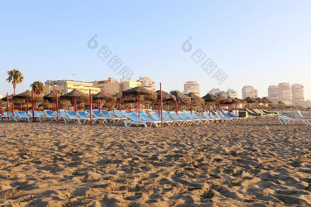 海滩躺椅和沙滩伞在孤独的沙滩。 科斯塔德尔索尔（太阳海岸），马拉加在安达卢西亚，西班牙