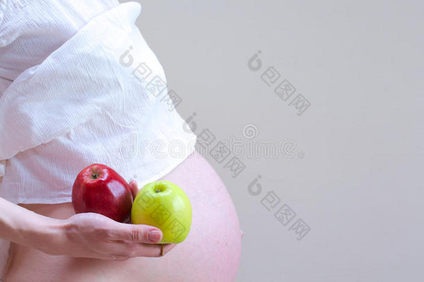 一个怀孕的女人，掌<strong>心里</strong>有两个苹果