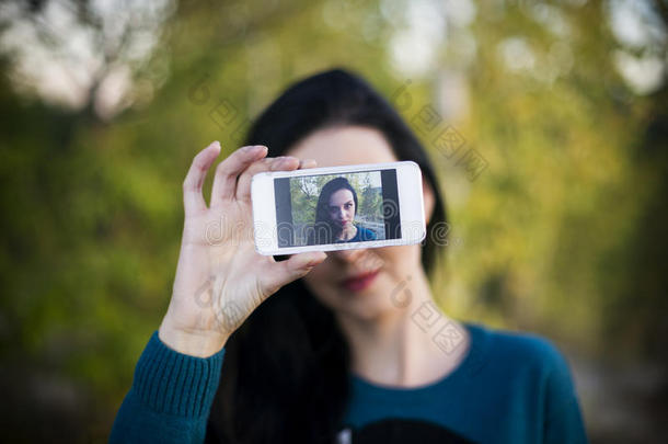 美丽的年轻女人在户外自拍