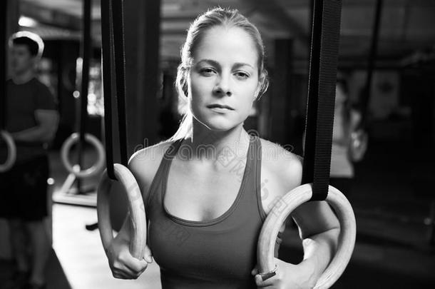 黑<strong>白镜</strong>头的女人使用体操戒指在健身房