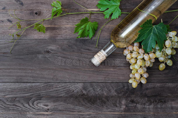 木制背景上的一瓶白酒和新鲜葡萄