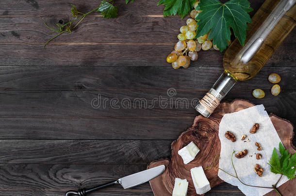 木制背景上的葡萄酒、新鲜葡萄、奶酪和核桃