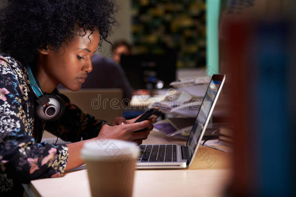 女办公室工作人员在办公桌上喝咖啡工作到很晚
