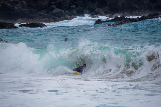 男孩身体冲浪者在夏威夷大浪中玩耍