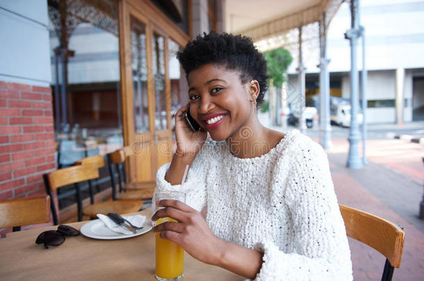 快乐的年轻女人在咖啡馆用<strong>手机</strong>说话