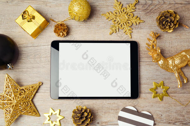 数字平板电脑模拟模板与圣诞装饰品在木制背景。 上面的视图表单