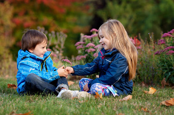 美丽的男孩和女孩在公园里，男孩给女孩送花
