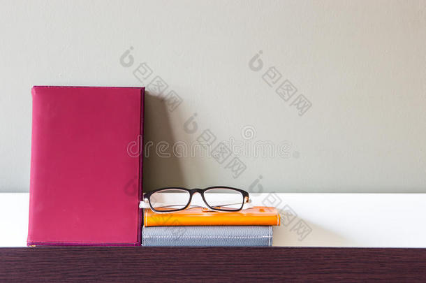 书架上的书、笔记本和眼镜